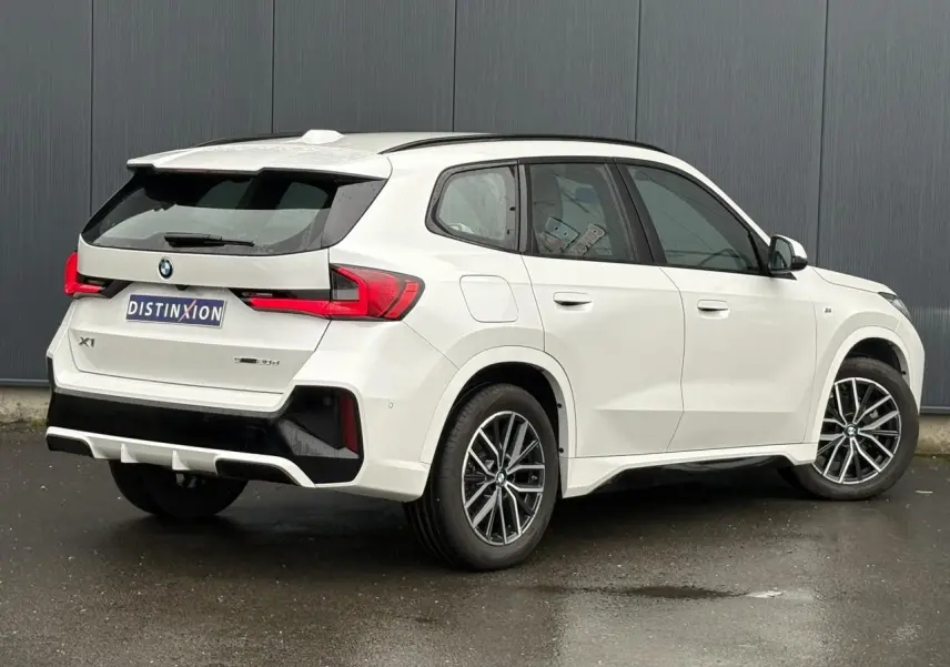 BMW X1 sDrive 20d blanc Mineral vue 3/4 arrière droit, jantes 18 pouces et feux LED distinctifs.