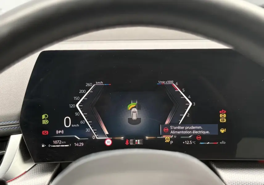 Vue rapprochée du combiné d'instrumentation numérique du BMW X1 blanc, affichant les indicateurs de vitesse et alertes.