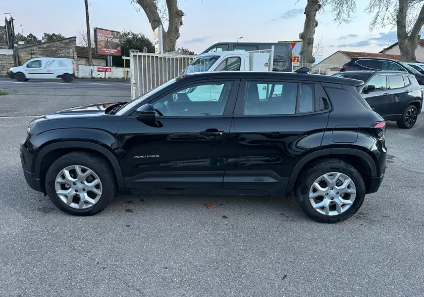 Vue de profil côté gauche d'un Jeep Avenger noir 2025 avec jantes alliage 17 pouces sur un parking extérieur.