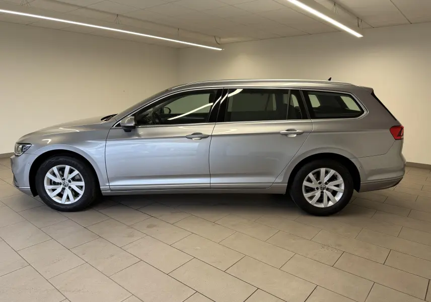 Volkswagen Passat SW 2.0 TDI 122 DSG7 Business en gris pyrite, vue profil côté gauche dans un intérieur neutre.