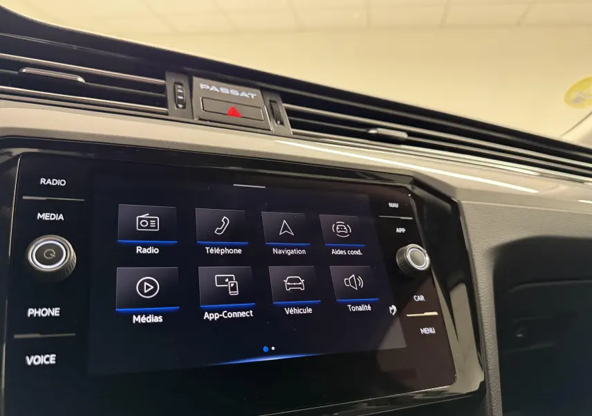Vue rapprochée de l’écran tactile central et tableau de bord de la Volkswagen Passat SW 2.0 TDI 122 DSG7 Business, intérieur noir.