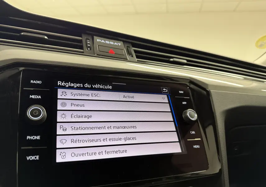 Vue rapprochée de l’écran tactile central de la Volkswagen Passat SW 2024 avec affichage des réglages du véhicule.