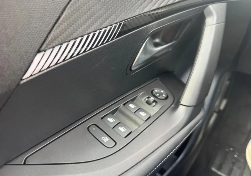 Gros plan sur la commande des vitres électriques côté conducteur de la Peugeot 2008 2024, finition Allure.