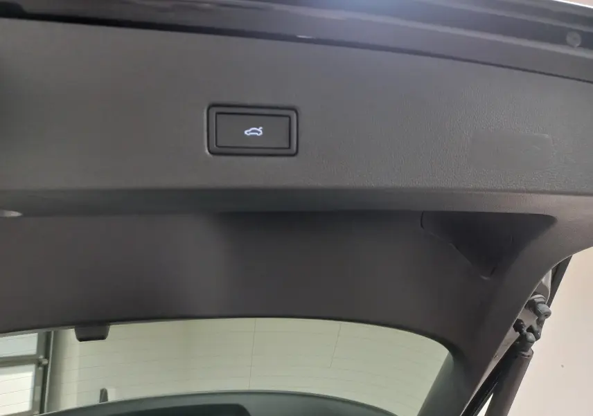 Détail du hayon électrique du Volkswagen T-Roc noir intense nacré, bouton d'ouverture main-libre visible.