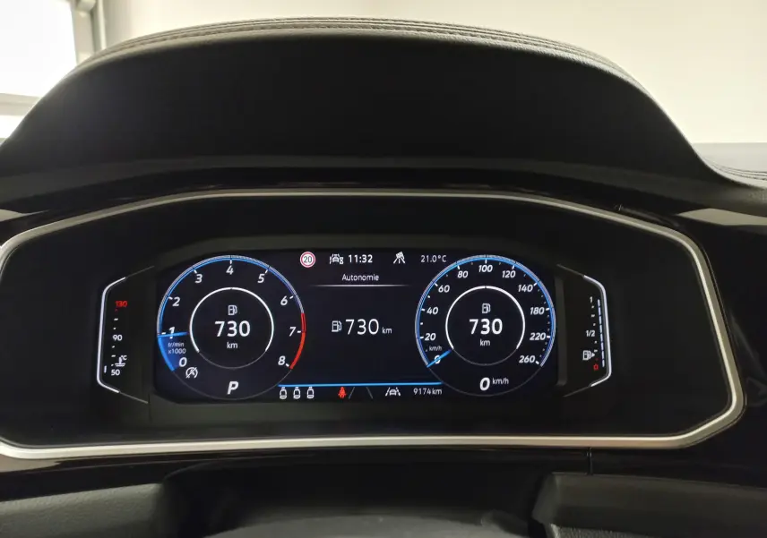 Vue rapprochée du tableau de bord numérique du Volkswagen T-Roc 2025, affichant l'autonomie et la vitesse à 0 km/h.