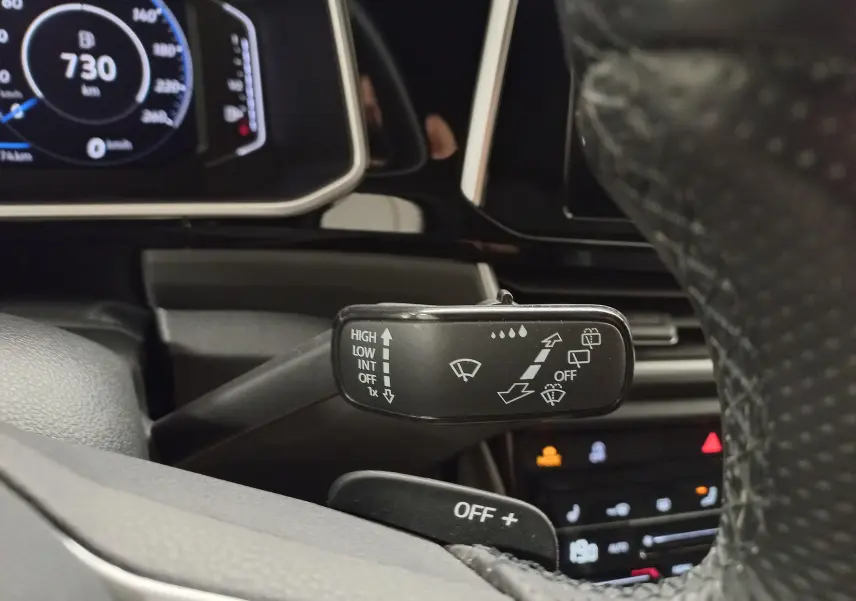 Gros plan sur la manette d'essuie-glace côté gauche du tableau de bord du Volkswagen T-Roc noir intense nacré 2025.