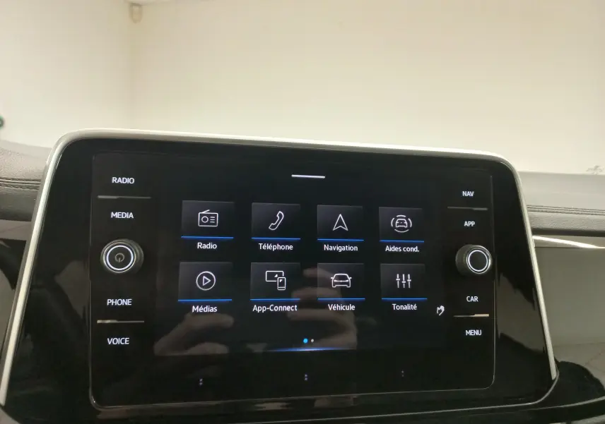 Écran tactile central du Volkswagen T-Roc 2025 affichant les options radio, navigation et aides à la conduite.