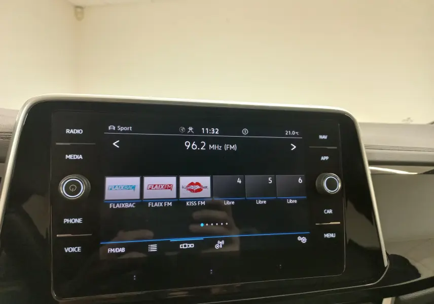 Vue rapprochée de l’écran tactile central du Volkswagen T-Roc 2025, affichant la radio FM sur fond noir brillant.