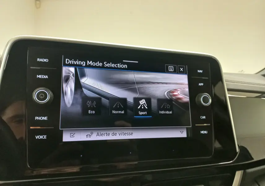 Vue rapprochée de l’écran tactile du Volkswagen T-Roc 2025 affichant la sélection du mode de conduite Sport.