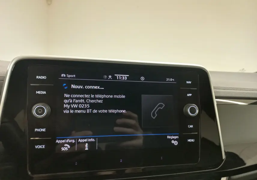 Écran tactile central du Volkswagen T-Roc 2025 affichant la connexion Bluetooth, avec commandes autour en finition noire brillante.