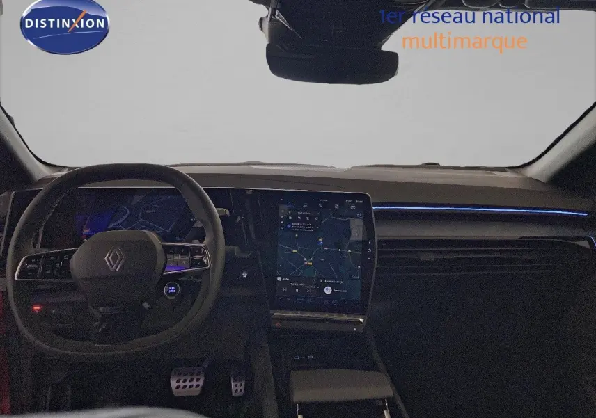 Vue intérieure du tableau de bord et volant de la Renault Rafale rouge flamme, avec écran tactile central et éclairage d'ambiance bleu.