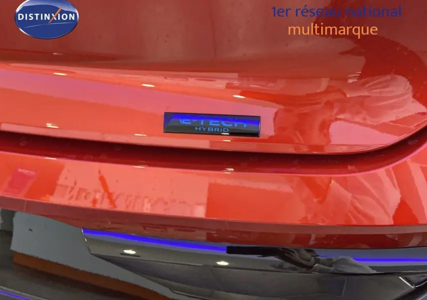 Gros plan sur le badge E-TECH Hybrid à l'arrière d'une Renault Rafale rouge flamme métal 2024.