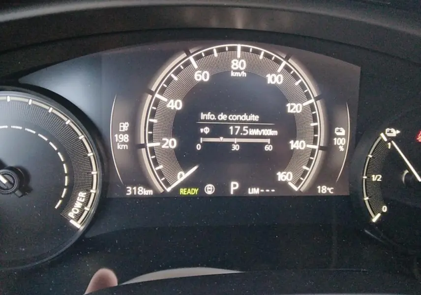 Tableau de bord du Mazda MX-30 électrique 2021 montrant la consommation et l'autonomie, affichage numérique clair.