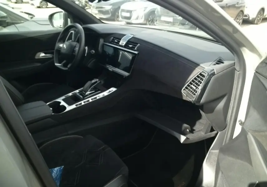 Vue intérieure côté passager du DS7 2024 gris laqué, mettant en valeur le tableau de bord et la console centrale en Alcantara noir profond.