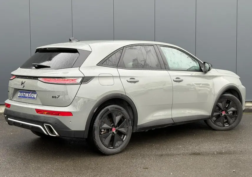 Vue 3/4 arrière droite du DS7 1.6 E-Tense 225 gris laqué avec jantes noires et feux arrière LED fins.