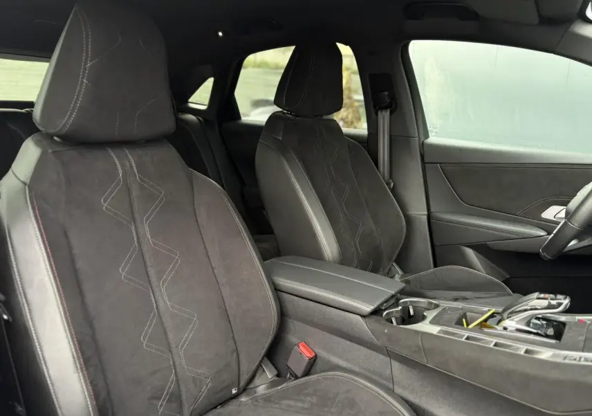 Vue intérieure côté avant droit du DS7 2024, sièges en Alcantara noir profond avec surpiqûres et console centrale élégante.