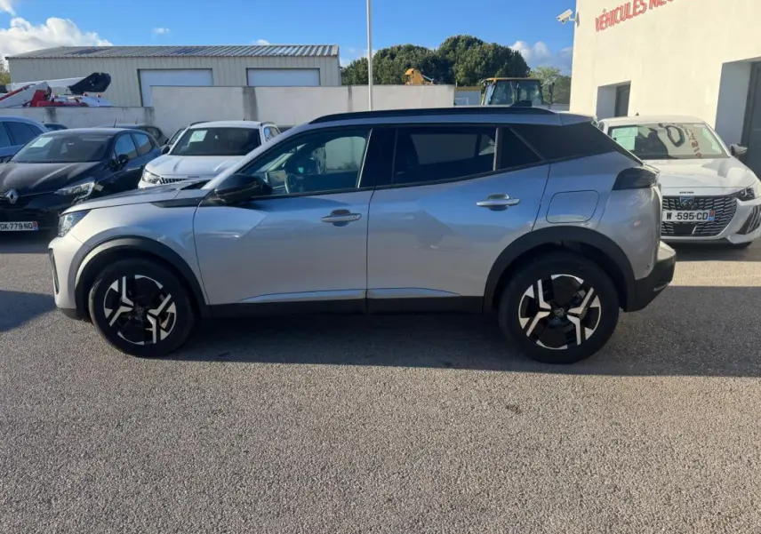 Peugeot 2008 Hybrid gris vue de profil côté gauche, avec jantes alliage 17 pouces et barres de toit noires.
