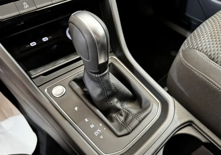 Gros plan sur la console centrale du Volkswagen Touran 2024, montrant le levier de vitesse automatique en cuir noir.