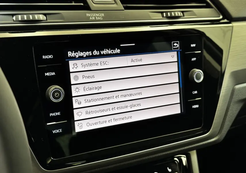 Vue rapprochée de l'écran tactile central noir affichant les réglages du véhicule dans l'habitacle du Volkswagen Touran 2024.