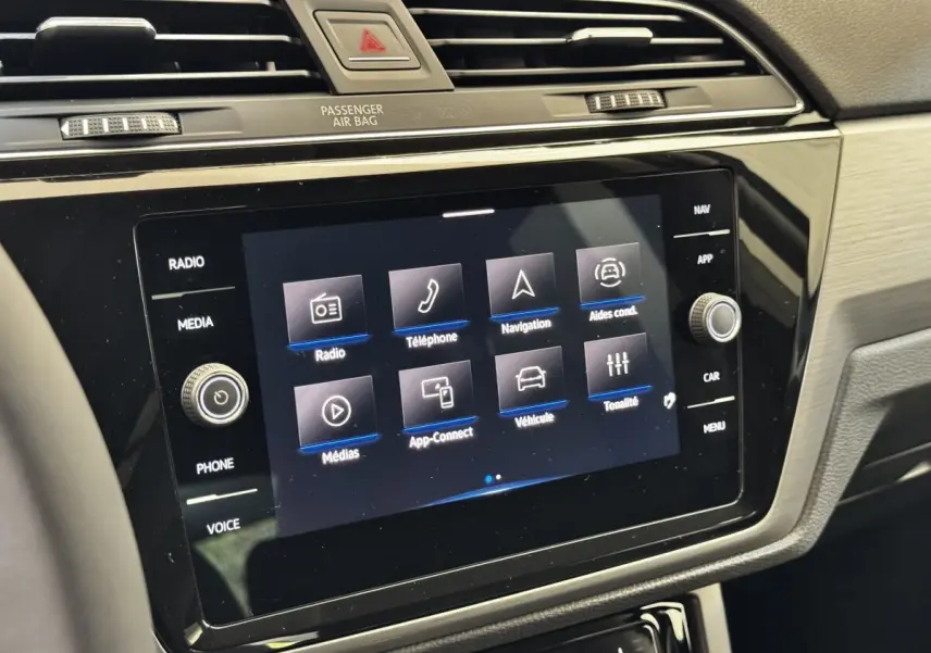 Vue rapprochée de l’écran tactile central du tableau de bord du Volkswagen Touran 2024, affichant les options multimédias.
