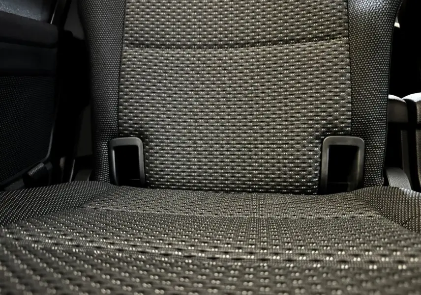 Gros plan sur le tissu gris texturé d’un siège arrière du Volkswagen Touran 2024, version 7 places.