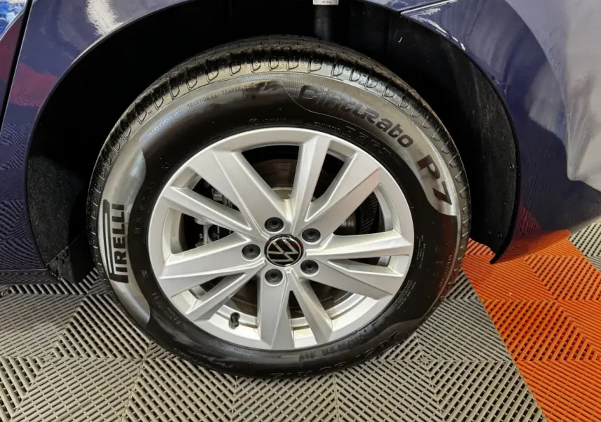 Gros plan sur la roue avant droite d’un Volkswagen Touran bleu 2024 avec jante argentée et pneu Pirelli Cinturato P7.