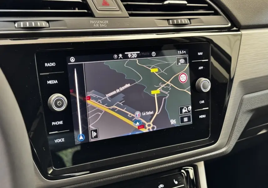 Écran tactile central du Volkswagen Touran 2024 affichant la navigation avec carte et commandes autour en intérieur gris.
