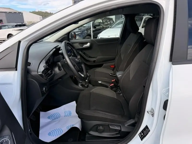 Vue intérieure côté conducteur du Ford Puma blanc 2026, mettant en valeur les sièges noirs et la boîte manuelle.