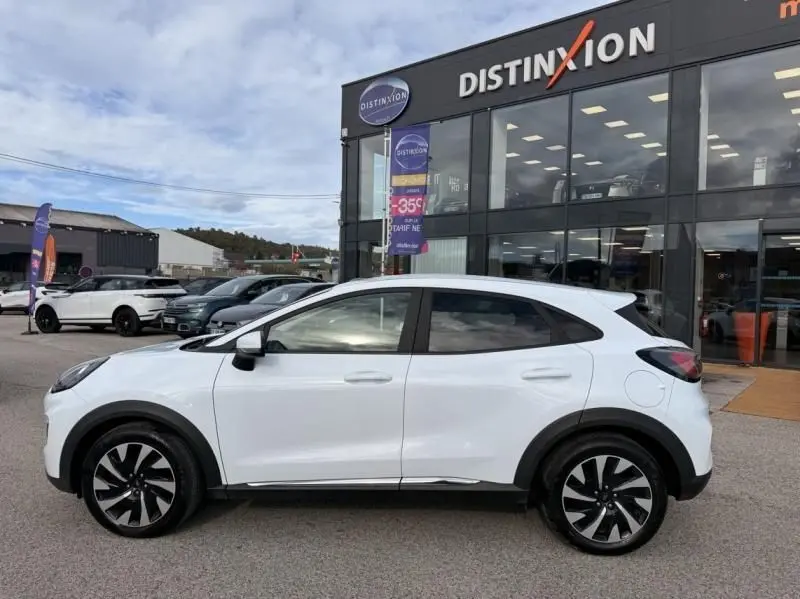 Vue de profil côté gauche d'un Ford Puma blanc 2026, version Titanium, avec jantes noires et détails chromés.