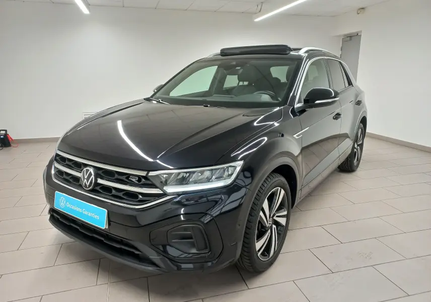 Volkswagen T-Roc noir intense en vue 3/4 avant droit, avec toit ouvrant panoramique et jantes R-Line distinctives.