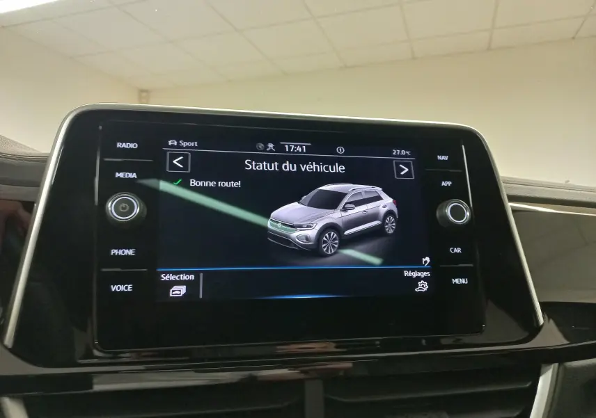 Écran tactile intérieur affichant le statut du véhicule Volkswagen T-Roc en vue 3/4 avant grise.