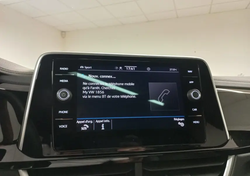 Écran tactile central du Volkswagen T-Roc 2025 affichant les options de connexion téléphone, intérieur noir brillant.
