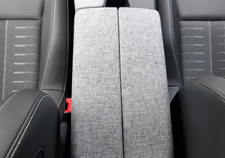 Vue plongeante sur l'accoudoir central gris clair et les sièges noirs du Peugeot 3008 1.2 Hybrid 145ch GT 2026.