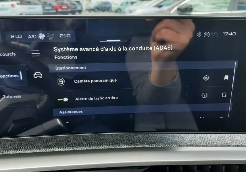 Écran tactile intérieur du Peugeot 3008 hybride 2026 montrant le menu d’aide à la conduite avec options caméra et alertes.