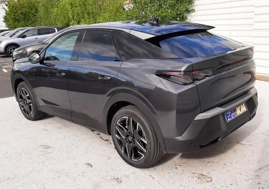 Peugeot 3008 gris titane avec toit noir, vue 3/4 arrière droit, jantes noires et vitres teintées.