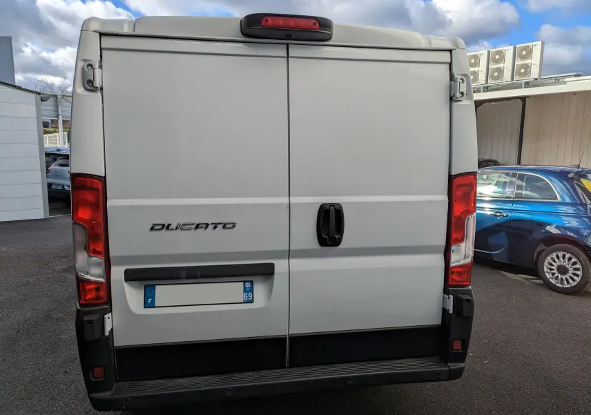 Vue arrière du fourgon blanc FIAT Ducato CH1 2.0 Multijet 115 ch avec portes battantes et feux rouges verticaux.