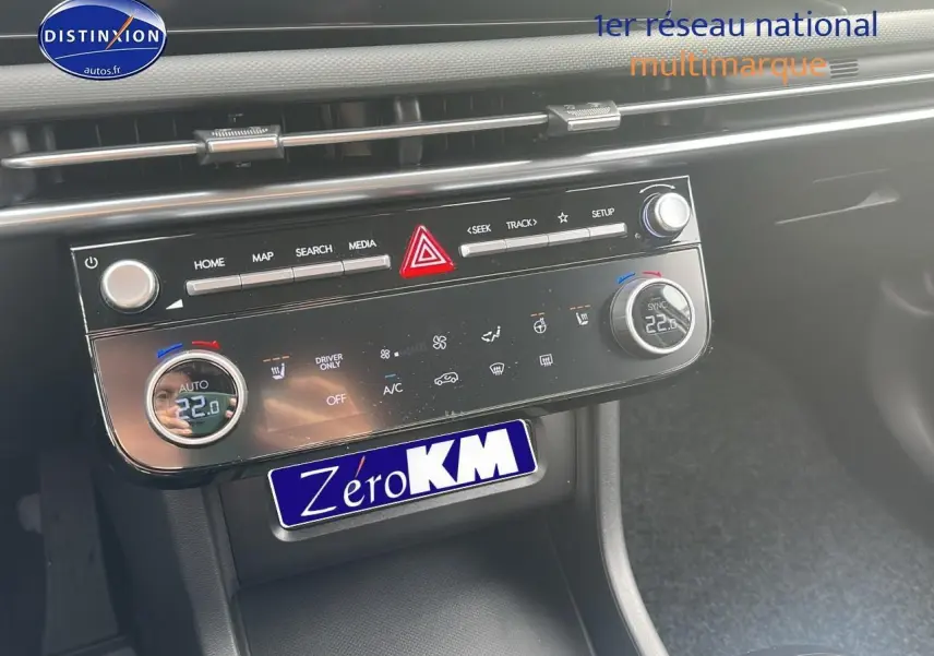 Tableau de bord du Hyundai Tucson 2025 avec commandes climatisation bi-zone et écran tactile noir brillant.