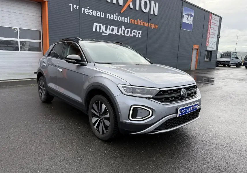 Volkswagen T-Roc 2025 argent pyrite métallisé en 3/4 avant droit, avec jantes alliage 'Zürich' et calandre noire distinctive.