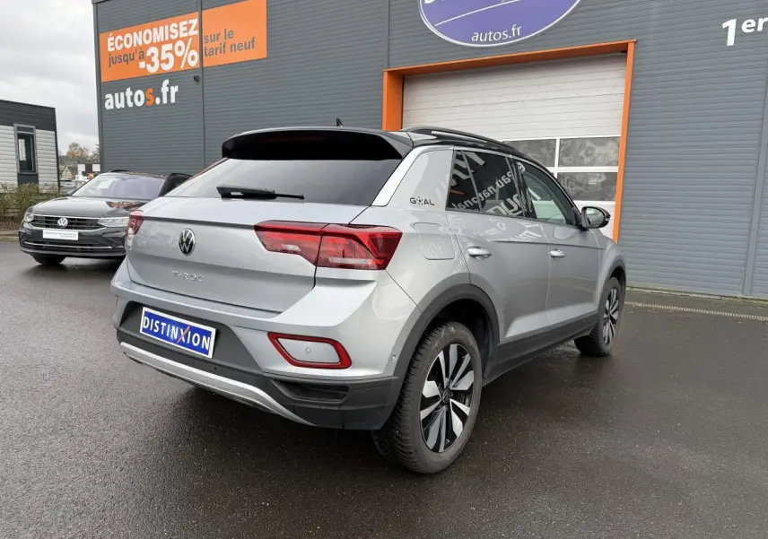 Volkswagen T-Roc argent pyrite métallisé vu en 3/4 arrière droit, avec jantes alliage et toit noir contrasté.