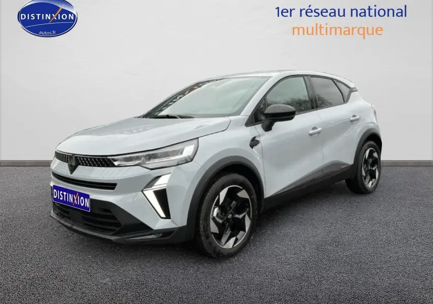 Renault Captur gris rafale en 3/4 avant droit, avec jantes noires et détails noirs contrastants.