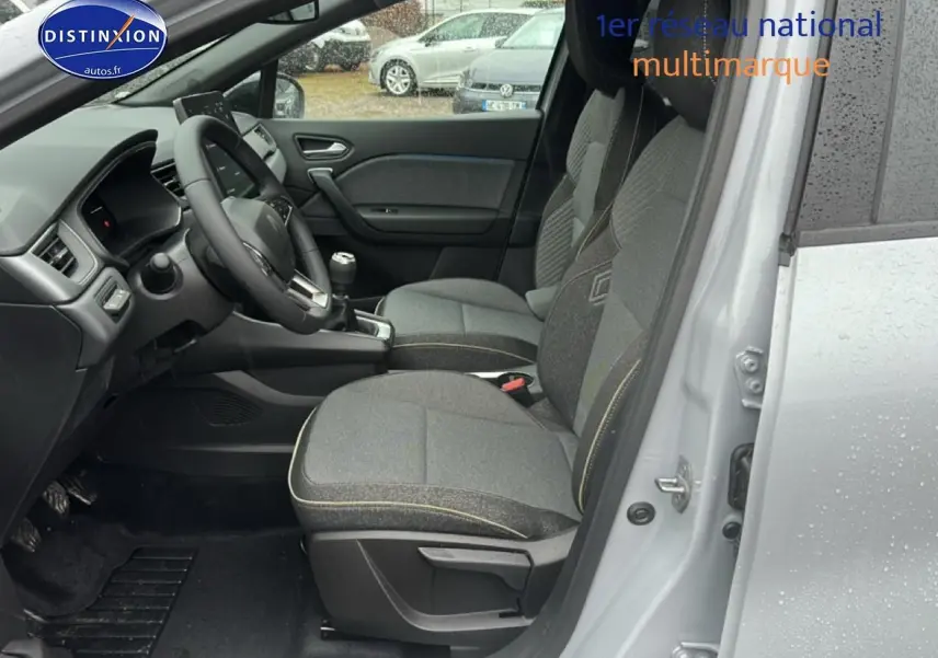 Intérieur côté conducteur du Renault Captur gris rafale 2026, sièges tissu gris et volant multifonction.