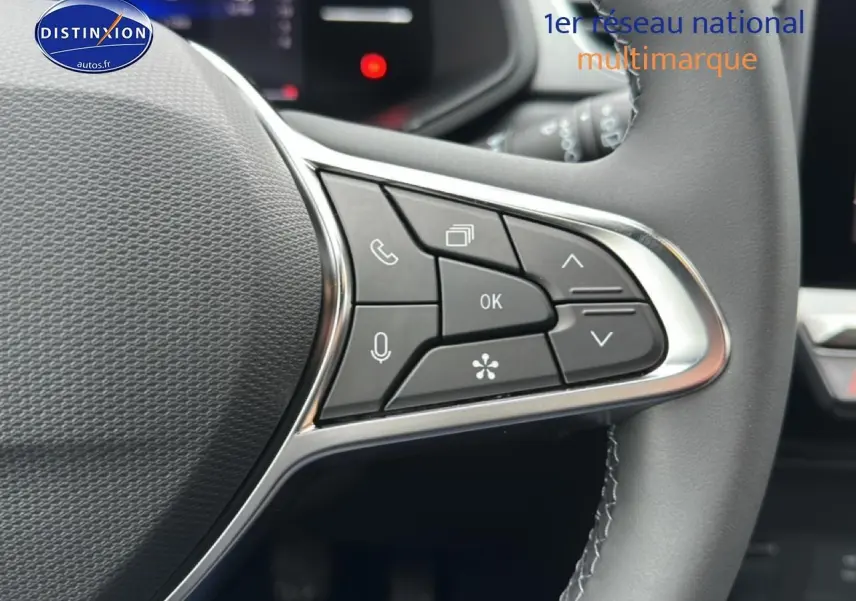 Gros plan sur les commandes multifonctions du volant du Renault Captur gris rafale, avec boutons de navigation et appel.