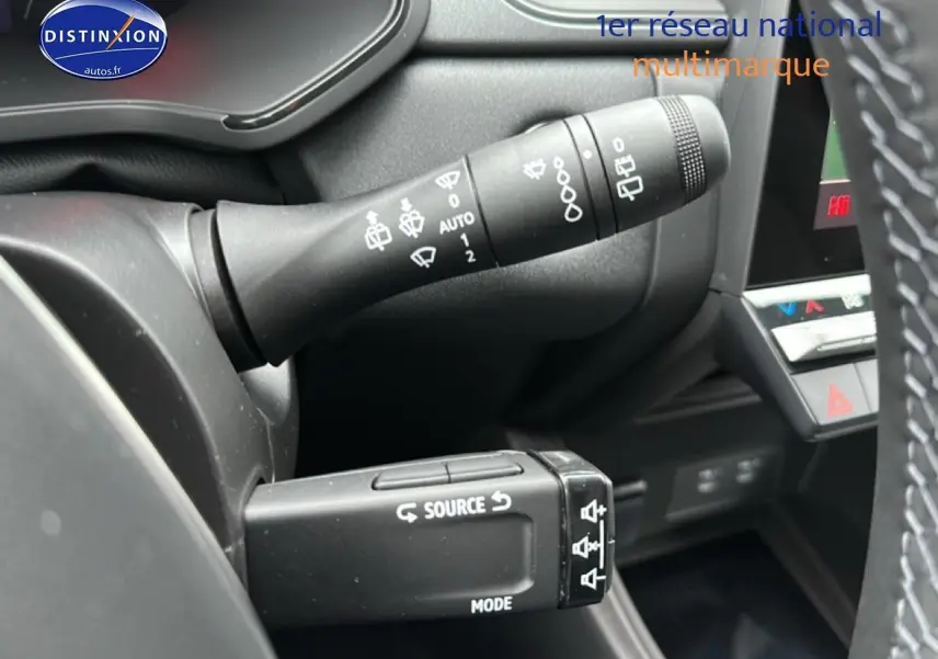 Gros plan sur les commandes au volant du Renault Captur gris rafale, mettant en valeur les fonctions source et mode.