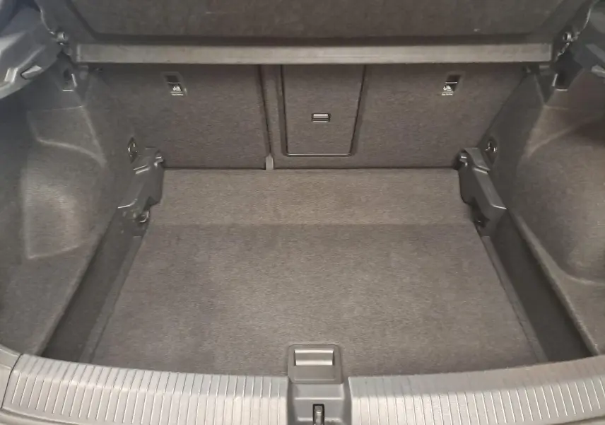Coffre vide vu de face du Volkswagen T-Roc 2025, revêtement intérieur gris foncé, sans chargement visible.