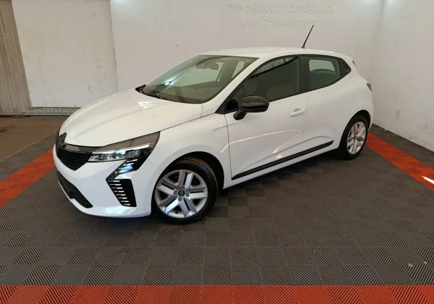 Renault Clio blanche vue 3/4 avant droit, avec jantes alliage et rétroviseurs noirs dans un intérieur lumineux.