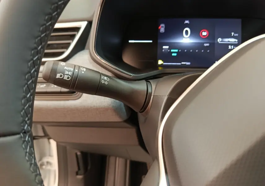 Gros plan intérieur sur le combiné d'instruments numérique et la commande des phares de la Renault Clio 2024.