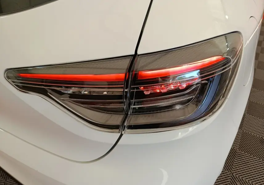 Gros plan sur le feu arrière droit rouge et noir d'une Renault Clio blanche 2024, vue arrière côté droit.