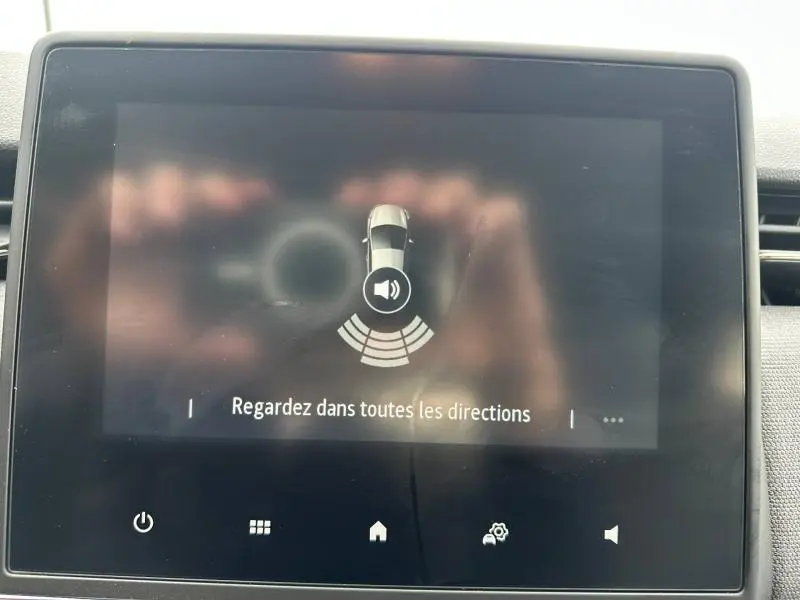 Écran tactile intérieur montrant l'alerte de proximité avec une Renault Clio grise vue de dessus, 2025.