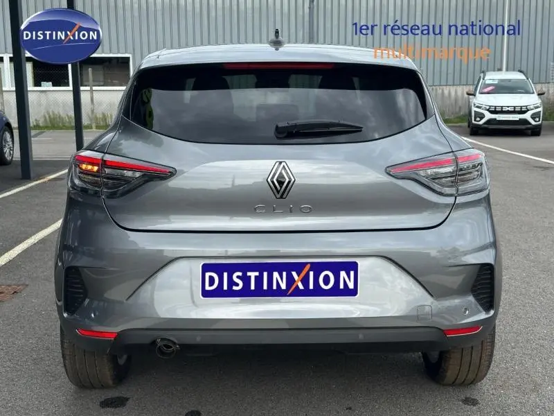 Vue arrière d'une Renault Clio gris métallisé 2025 avec feux LED et logo distinctif sur un parking.