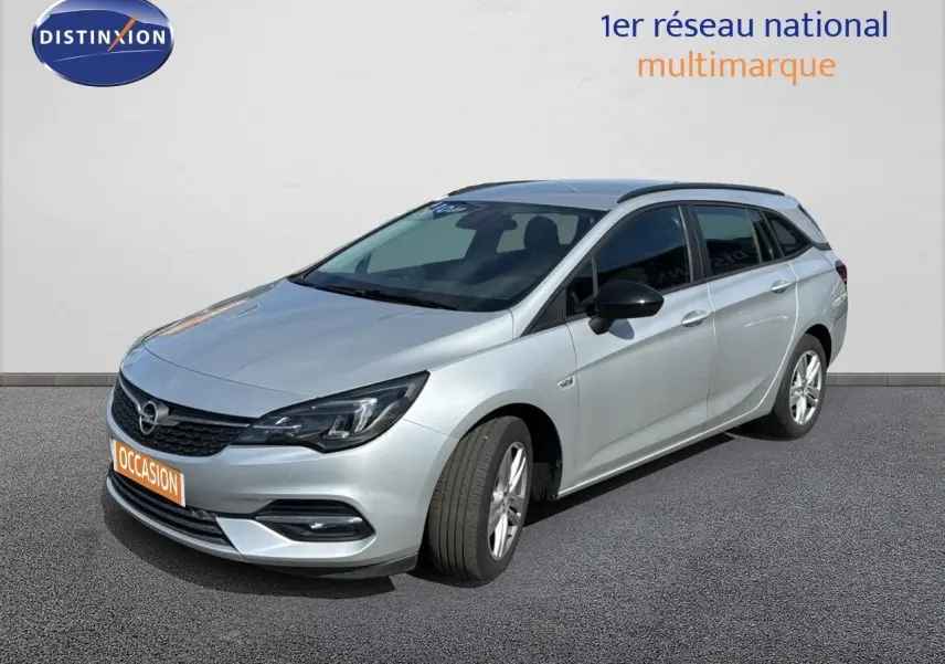 Opel Astra Sports Tourer gris minéral métal vue 3/4 avant droit sur fond neutre avec calandre noire.